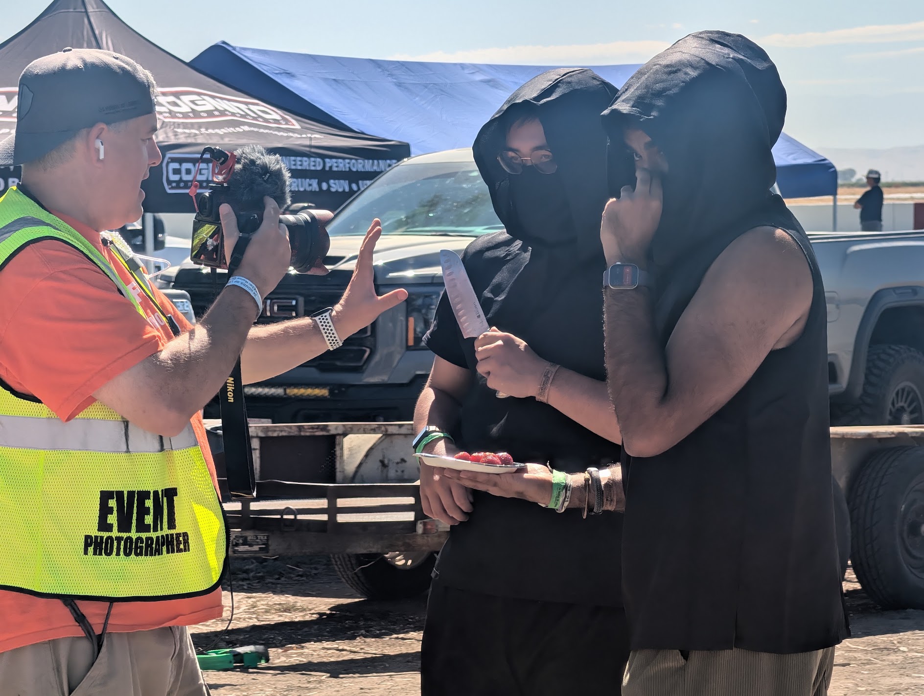 An event photographer interviews two RN Racing members in ninja outfits.